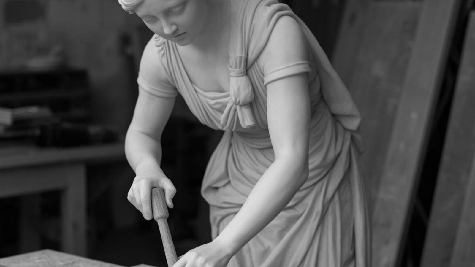 Marmorstatue af kvinde, der arbejder med et redskab